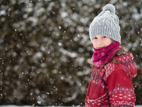 Cute young girl walking in a snow storm