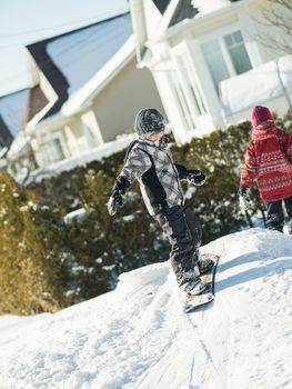 Boy playing in the snow with a snowboard