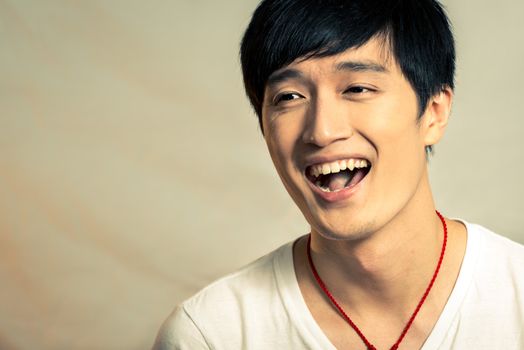 Young man laughing with fashion tong and background