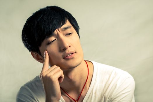 Young man looking deep in thought, in fashion tone and background