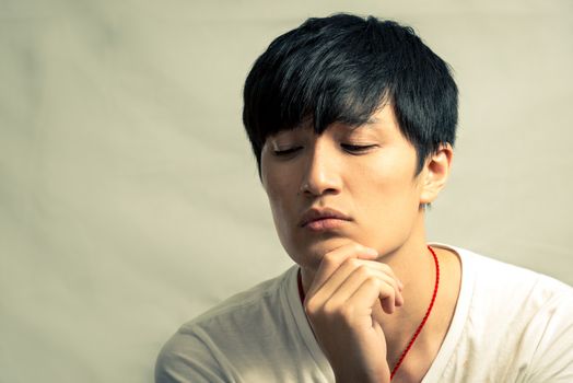 Young man looking deep in thought, in fashion tone and background