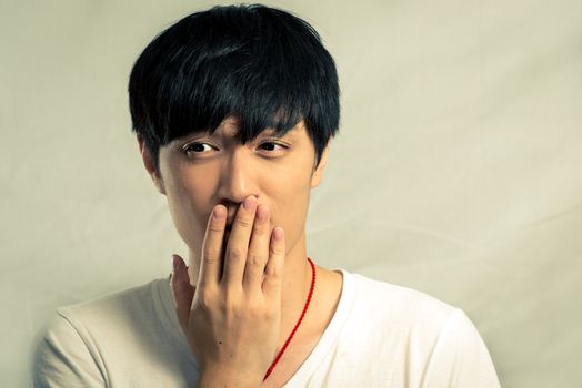 Portrait of young man smiles and looking shy, with fashion tone and background