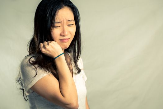 Young woman crying while pulling her hair, with fashion tone and background