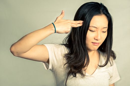 Depressed young woman hand signals suicide, with fashion tone and background