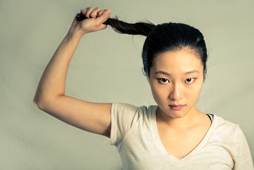 Young woman pulling her hair looking frustrated, with fashion tone and background