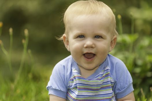 Head and shoulders portrait of a happy blonde baby boy.