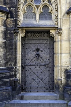 Medieval castle door with door knocker, handle and ornaments.
