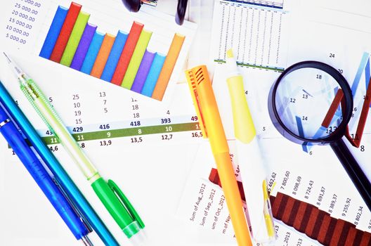 Arrangement of Graphs, Charts, Pencils and Pens, Felt Tip Pen and Magnifier. Top View