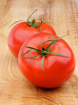 Two Perfect Ripe Tomatoes with Twigs closeup on Wooden background