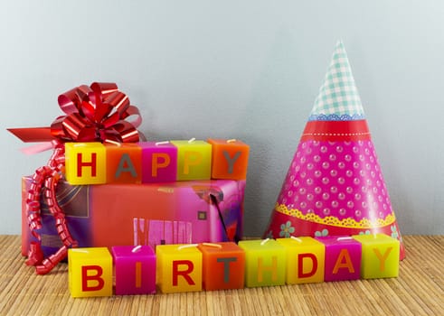 happy birthday candles with present and blue wallpaper