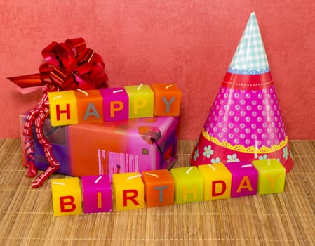 happy birthday candles with present and red wallpaper