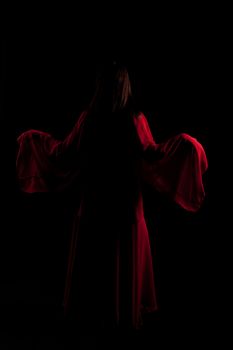 Young girl in red dance in a darkness
