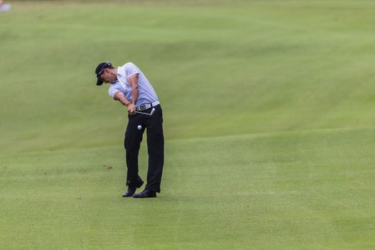 Golf professional playing iron shot to green at volvo tournament at Durban Country Club South Africa.