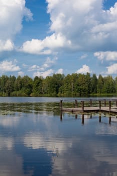 Lake landscape with forest and wooden gangway
