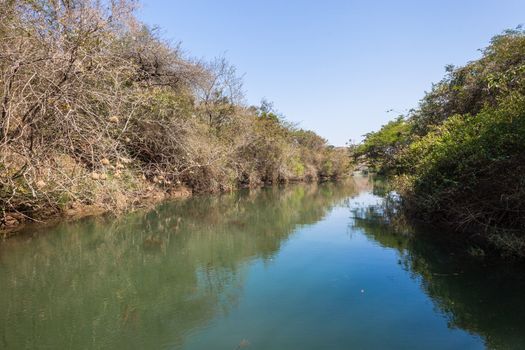 River channel estuary towards dam lake waters with surrounding bush vegetation