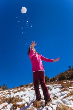 Young girl throwing winter snowball
