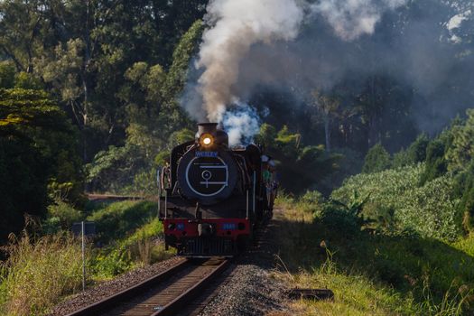 Steam train engine and passenger coaches on tourist line destination