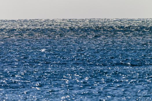 High winds over blue ocean giving texture and chop on water surface.