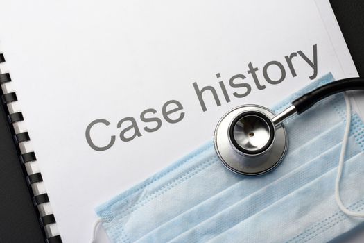 Case history, stethoscope and mask on black