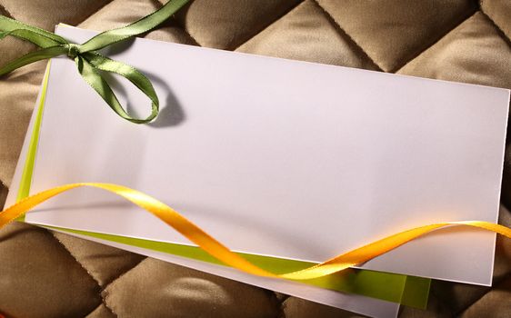 Blank greeting card with ribbons on checked background