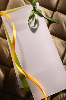 Blank greeting card with ribbons on checked background