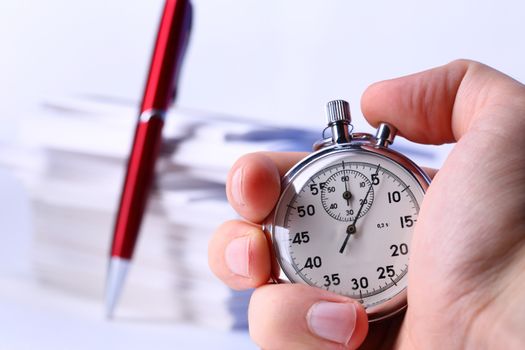 Stopwatch in hand on background of paper cards