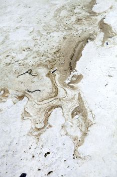 An dark oily substance on the sand at the beach.