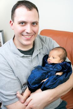 Cute newborn baby girl being held by her dad.