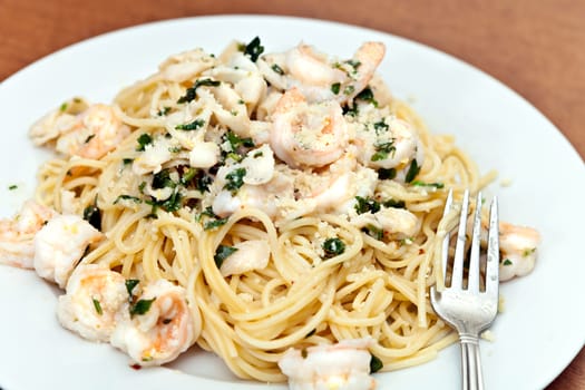 A delicious shrimp scampi pasta dish with calamari parsley garlic and olive oil. Shallow depth of field.