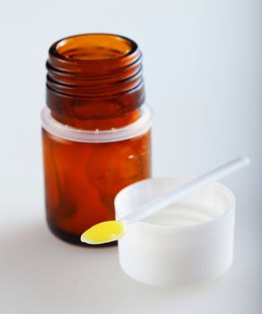 Royal jelly over plastic scoop, over white background