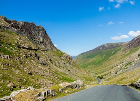 Narrow road leads down from Honister Pass in the English Lakes or Lakeland Lake District in Cumbria