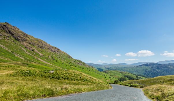 Narrow road leads down from Honister Pass in the English Lakes or Lakeland Lake District in Cumbria