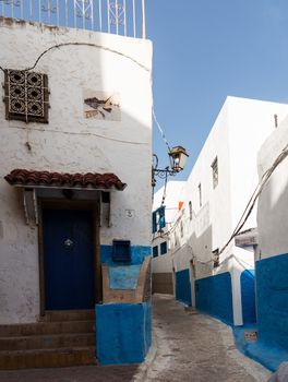 Narrow street or path in the Medina or old town of Rabat in Morocco with blue and white painted homes