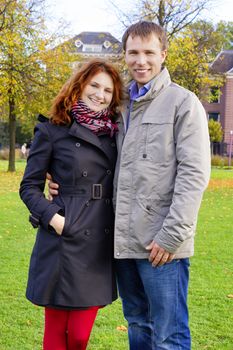 Outdoor happy couple in love posing against autumn Amsterdam background