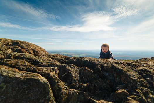 Infant boy climbing a mountain in Quebec