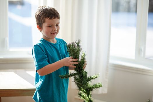 Boy building a Christmas tree inside a house