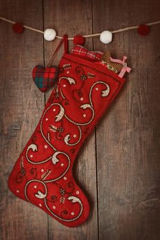 Christmas ornaments in stocking hanging on wood 