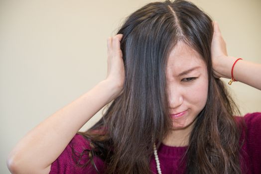 Young woman holding her head looking frustrated