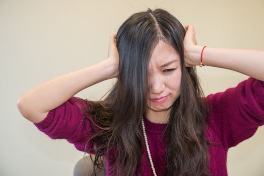 Young woman holding her head looking frustrated