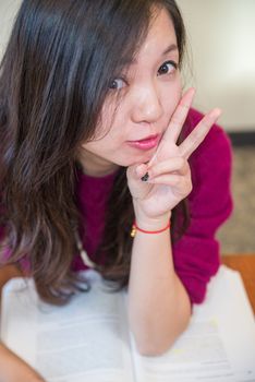 Woman studying with a book looking happy