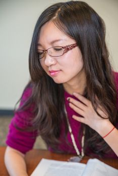 Portrait of young woman with glasses and book