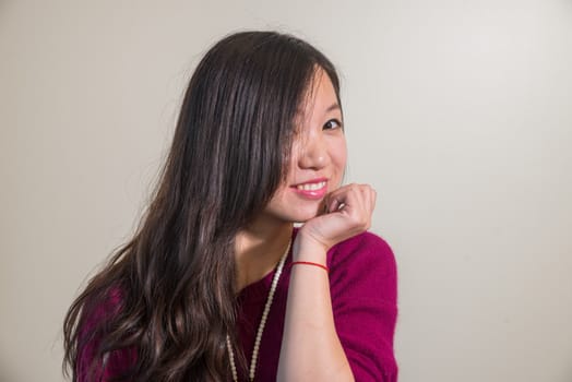 Portrait of cute lookign young woman posing with gray background