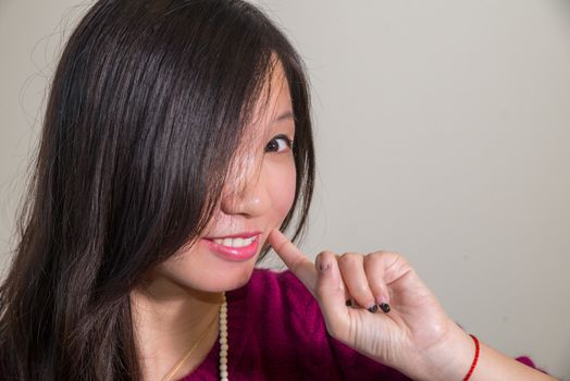 Portrait of cute lookign young woman posing with gray background