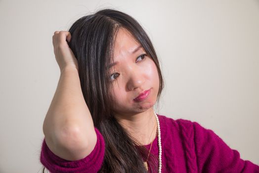 Young woman scratching head looking confused