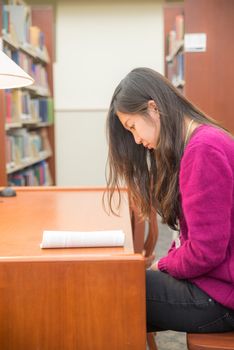 Woman with book studying in library