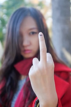 Young woman showing hand sign looking angry