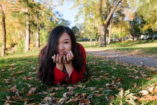 Woman laying on grass looking happy