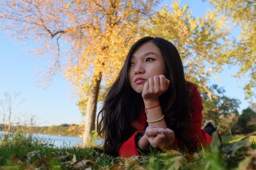 Woman laying on grass looking happy