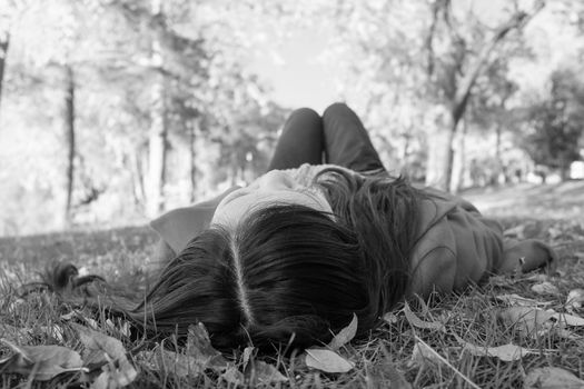 Young woman laying on grass looking at the sky