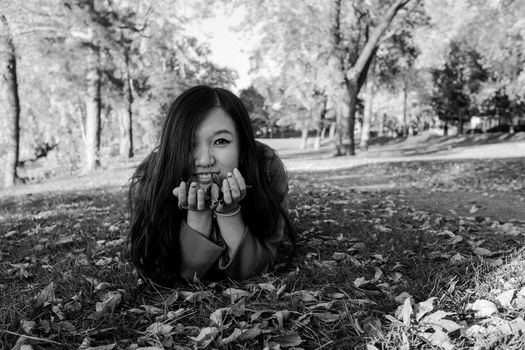 Woman laying on grass looking happy